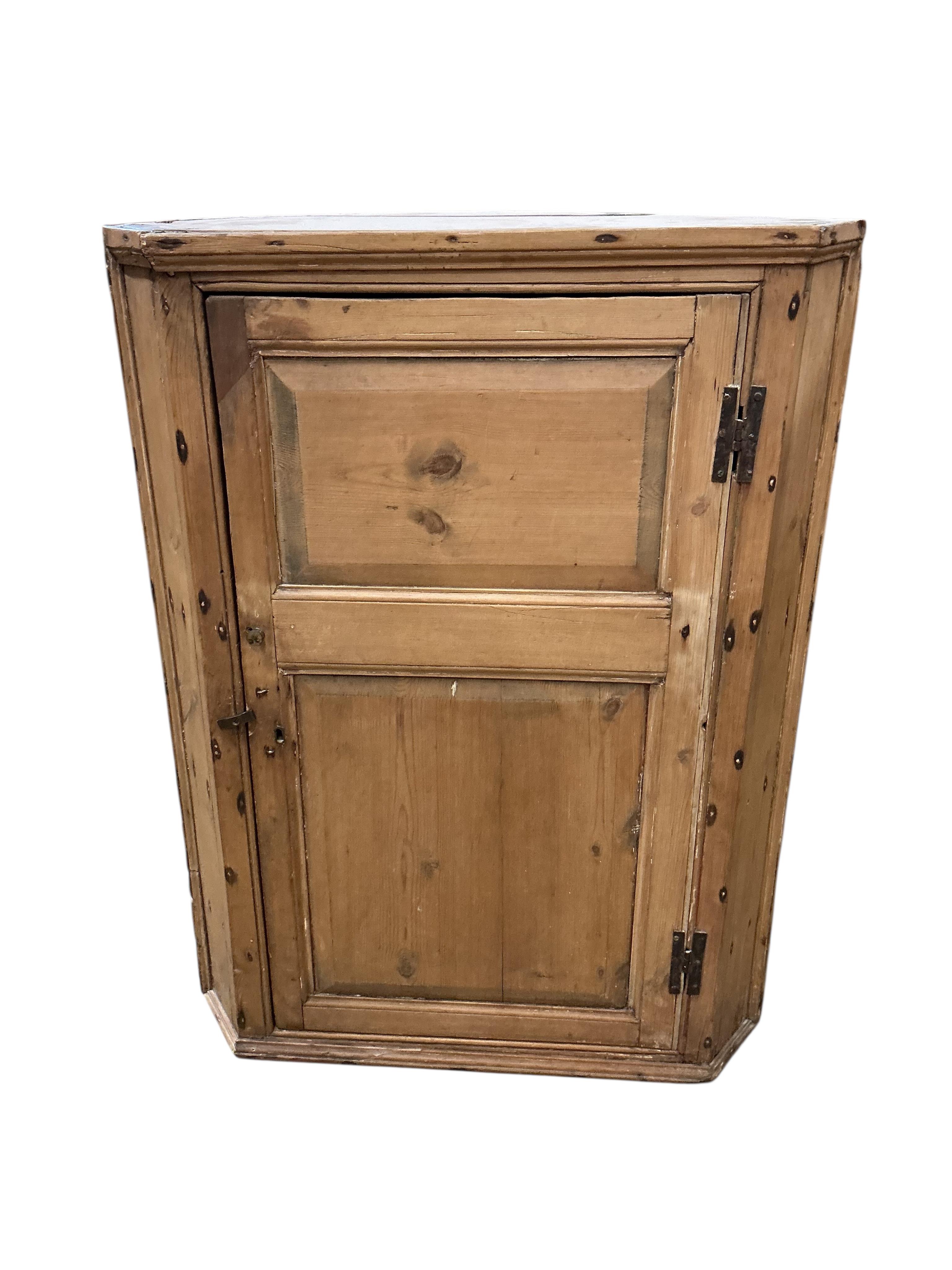 An early 19th century pine hanging corner cupboard, width 67cm, depth 43cm, height 88cm